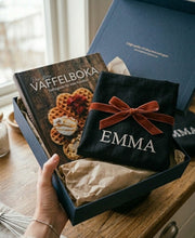 Last inn bildet i Galleri-visningsprogrammet, Vaffelduft og gode tradisjoner. Stor vaffelbok og sort forkle med lomme og personlig brodering